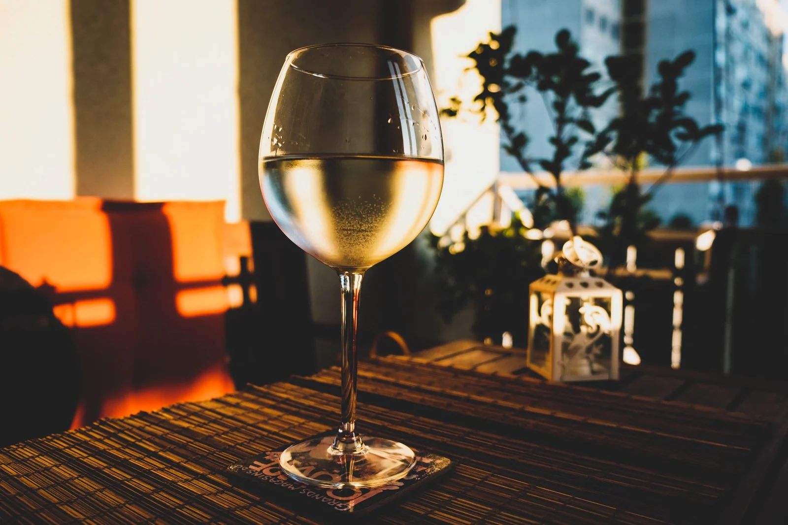 Verre posé sur une table de terrasse avec la lumière du soir en arrière-plan